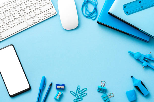 istock Blue colored office desk frame with computer keyboard and mouse, mobile phone and office accesories. Copy space. 1583048026