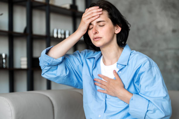 istock Woman sitting on sofa and having asthma or panic attack 1583051832