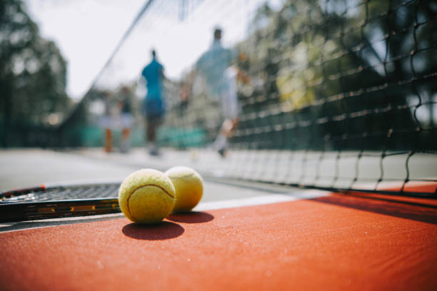 palla da tennis e racchetta su campo duro sotto la luce del sole - toughness surface level court tennis foto e immagini stock