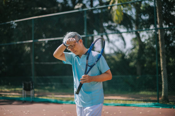 주말 아침 테니스 경기 후 이마에 땀을 닦는 지친 중국 노인 - tennis asian ethnicity male forehand 뉴스 사진 이미지