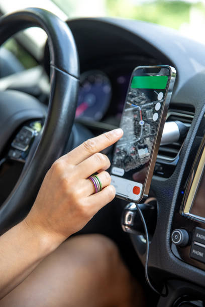 istock Female driver hand holding a phone with interface navigator on a screen. 1583056202