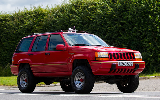 Bicester,Oxon,UK - June 19th 2022.  1994 red Jeep Cherokee car driving on an English country road