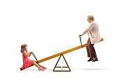 Grandmother and granddaughter swinging on a seesaw