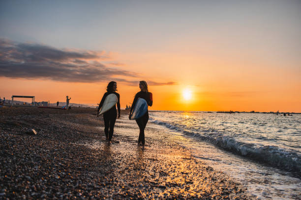 istock Two Young Female Surfers Having A Conversation Before A Sunrise Surf Session In Barcelona 1583061431