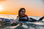 Attractive Young Adult Female Trying To Catch A Wave During An Early Morning Surf Session