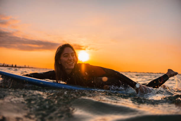 istock Adventurous Surfer Girl Practicing Her Surfing Skills At Sunrise 1583063603