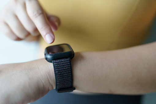 Woman workoutÂ with health appÂ on smart watch Close-up hands.