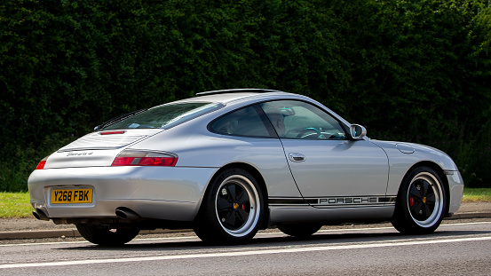 Bicester,Oxon,UK - June 19th 2022.  2001 silver Porsche 911 car driving on an English country road