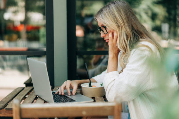 istock Business woman working remotely while sitting in a cafe in summer. 1583072406
