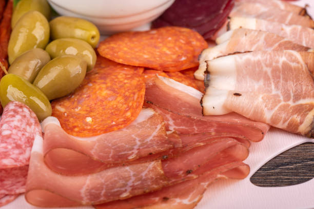 istock Green olives and sliced bacon, prosciutto, chorizo. 1583075373