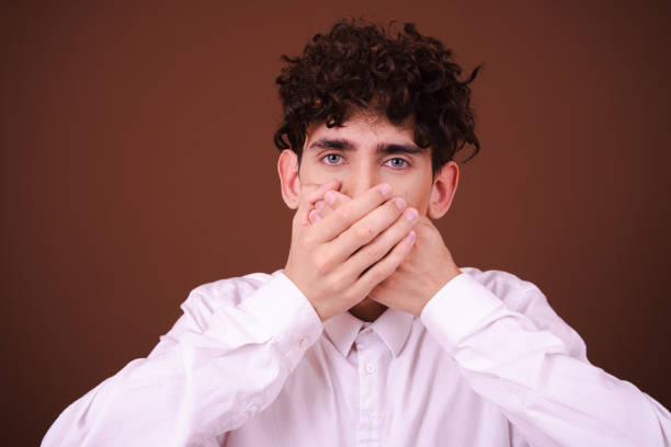 istock Young funny guy in headphones posing on a brown background. 1583090253