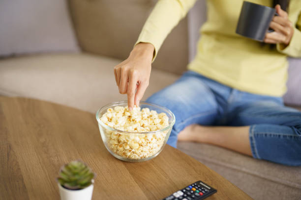 istock Asian woman Watching smart TV and using remote controller Hand holding television audio remote control at home with the remote control television 1583094789