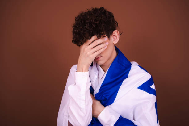 Attractive guy posing with the Israeli flag on a brown background.