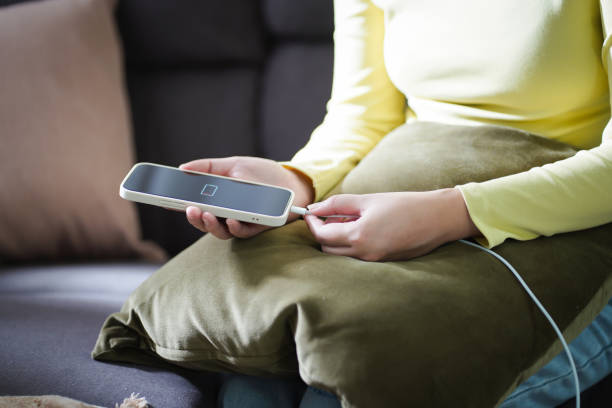 istock Woman hands Charging mobile phone battery with low battery. plugging a charger in a smart phone Â with energy bank powerbank power charger Modern lifestyle energy technology concept. 1583095929