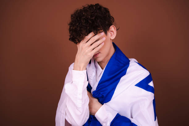 istock Attractive guy posing with the Israeli flag on a brown background. 1583098680