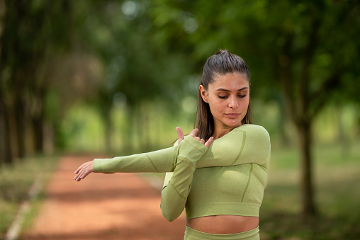 a girl stretches and prepares for a run in the park