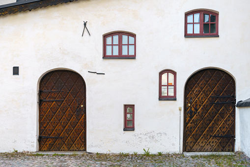 Historic wooden doors and windows on a white stone wall. Cathedral of Porvoo, Finland.