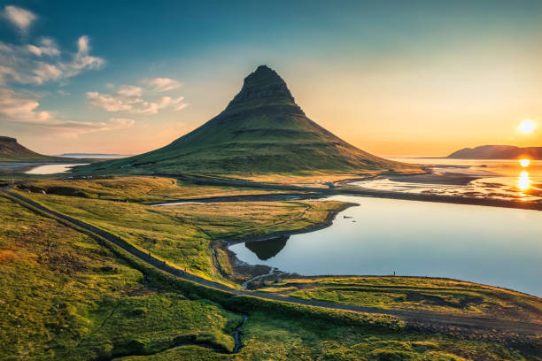 Volcano Kirkjufell mountain with lake reflection during sunrise morning in summer at Iceland Panorama of majestic symmetry volcano Kirkjufell mountain with lake reflection during sunrise morning in summer at Snaefellsnes peninsula, Iceland kirkjufell stock pictures, royalty-free photos & images