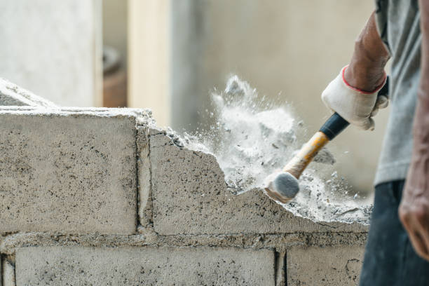 Hand of worker using hammer smashing and demolish on brick wall at construction site stock photo
