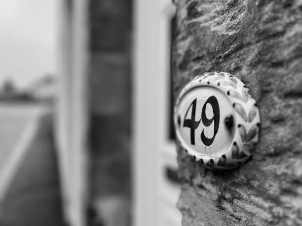 A house number plaque on a stone wall