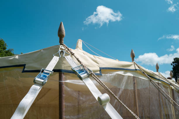 Tethering nylon straps seen at the corner of a large celebration marquee. The translucent side material shows the inside of the marquee.