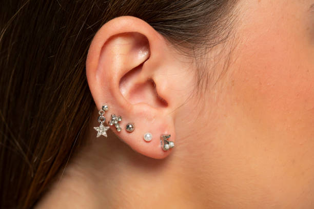 ear piercings photos.Helix piercing.Ear rings stock photo