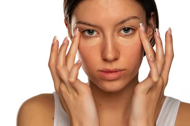 istock Portraitf young woman with blue eyes applying concealer under her eyes 1583177567