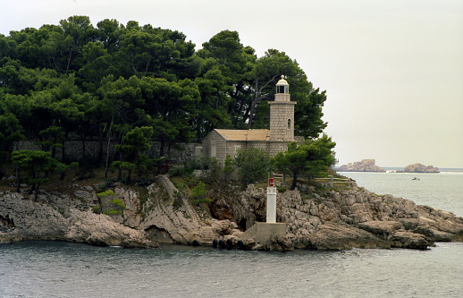 analogue photo of a lighthouse on the rock at the entrance to the port of Dubrovnik