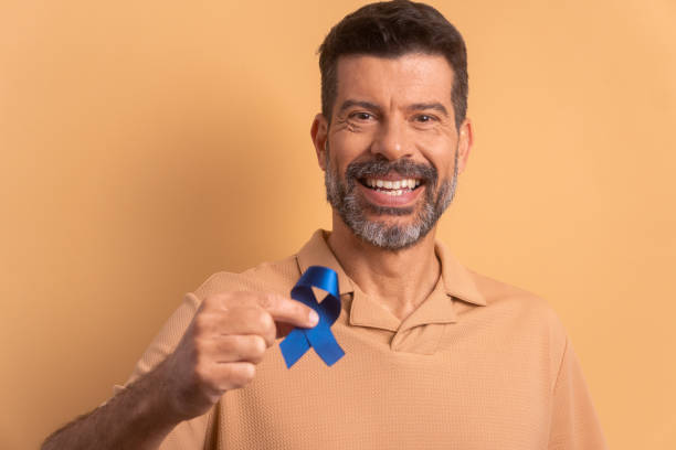 istock mature man showing blue ribbon 1583202301