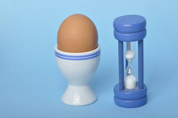 istock Boiled egg and hourglass on a blue background 1583202831