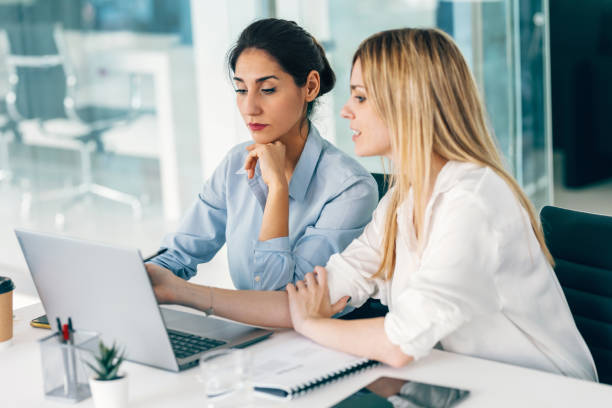 istock Two elegant businesswomen talking while working together in a modern startup 1583206867