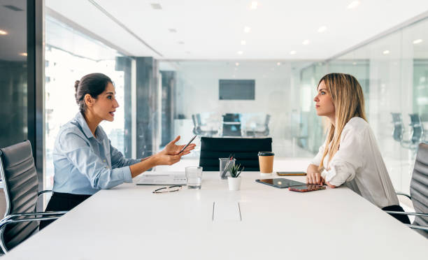 istock Two elegant businesswomen talking while working together in a modern startup 1583208461