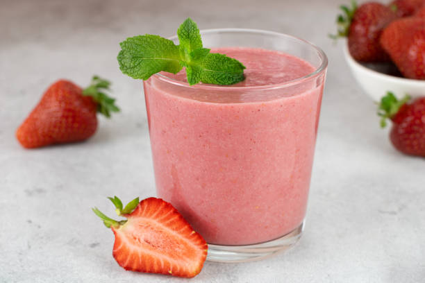 istock Strawberry smoothie or cocktail with berries on a gray background. Summer beverages. 1583222985