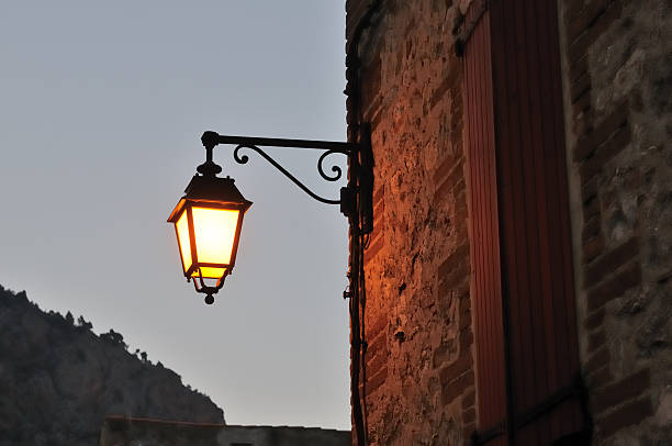 Lighted lamppost in the evening Lighted lamp post at dusk, in the city of Villefranche de Conflent, in the Pyrenees region (French Catalonia) villefranche de conflent stock pictures, royalty-free photos & images