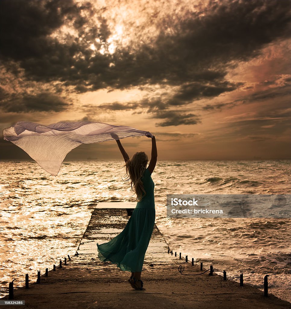 Woman in Dress with Fabric at Sea Photo of Blonde Woman with Scarf at the Sea One Woman Only Stock Photo