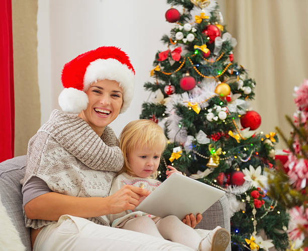 istock Happy mother and baby using tablet PC near Christmas tree 158324833