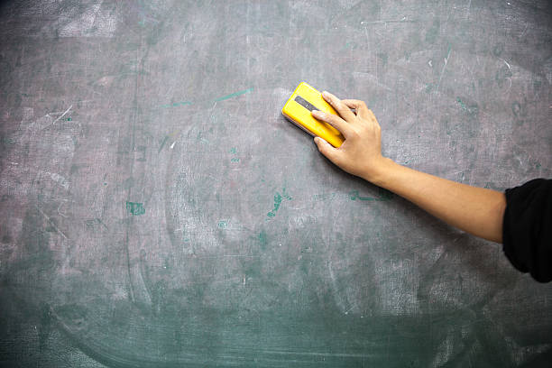 cleaning blackboard hand with blackboard eraser cleaning blackboard board eraser stock pictures, royalty-free photos & images