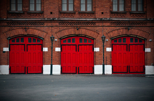 Facade of an old Fire Station with red doors..