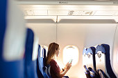Woman in the airplane holding smart phone with white screen