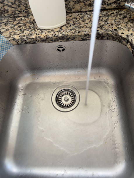 istock Water running in stainless steel sink 1583333413