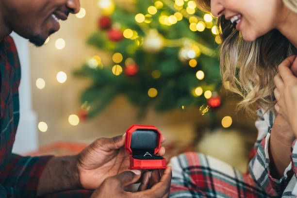 istock Young man proposing to his girlfriend on Christmas Eve 1583348227