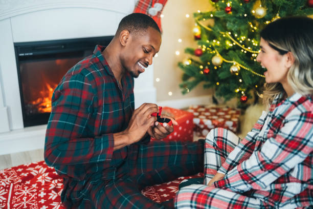 istock Young man proposing to his girlfriend on Christmas Eve 1583349343