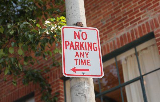 No Parking sign on a city street, representing order, restriction, and urban regulations. Symbolizes vehicular control and maintaining orderly spaces