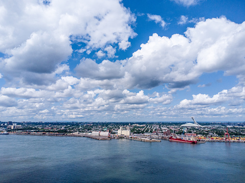 Aerial view of Montreal Olympic stadium and St. Lawrence river from South Shore during summer day
