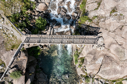 vertical aerial view of the wooden bridge over cornisello lake in trentino