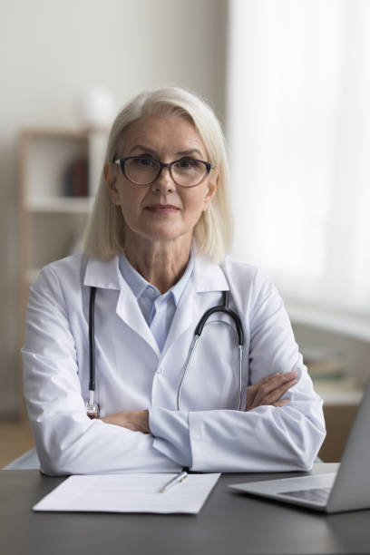 istock Confident mature practitioner woman in glasses posing with crossed hands 1583407608