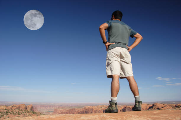 Hiker, Canyons and Moon stock photo