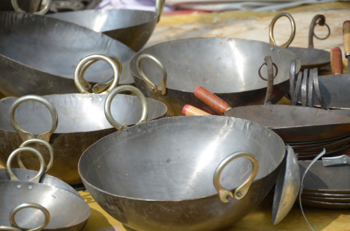 Woks and griddles for sale at the Pushkar Camel Fair. This annual fair maybe the only opportunity for some nomadic tribes to purchase household goods. Pushkar, Rajasthan, India.