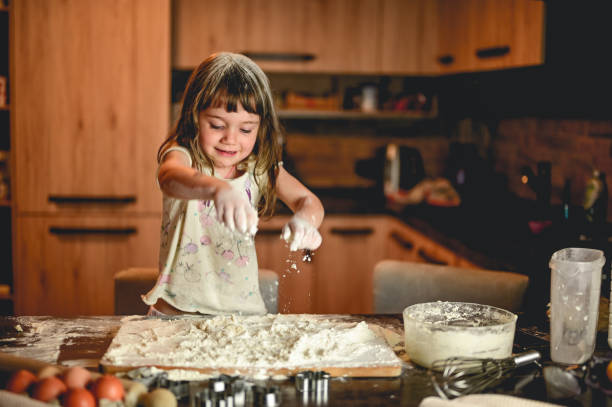 istock preschool girl preparing dough for baking cookies. 1583444837