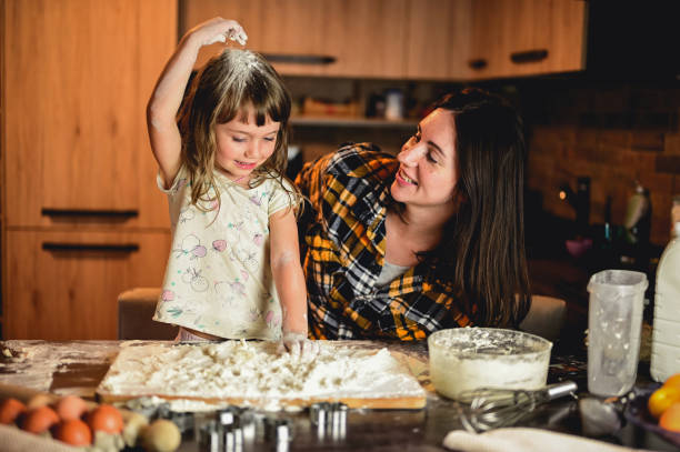 istock mother with daughter baking together. 1583445826